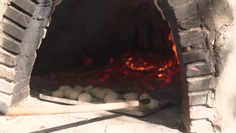 Cooking bread in clay oven traditional bakery