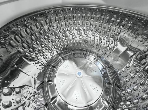 Looking inside of a stainless steel washer drum of an automatic washing machine