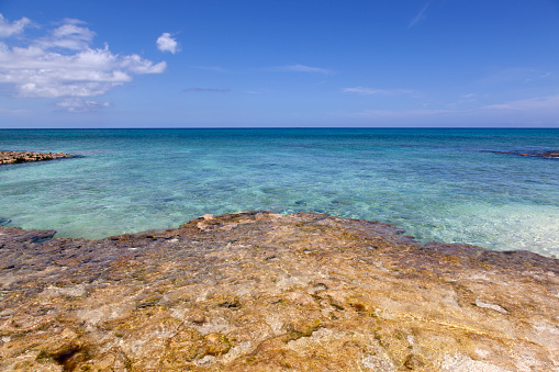 The scenic view of rocky Gran Cayman island Seven Mile Beach and turquoise color Caribbean Sea (Cayman Islands).