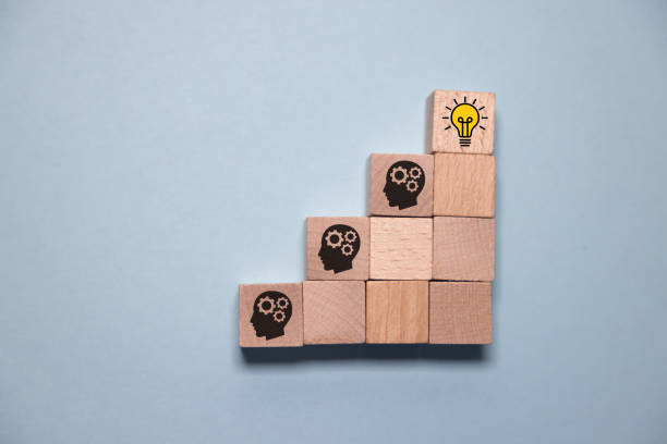 istock Concept creative idea and innovation. Hand picked wooden cube block with head human symbol and light bulb icon. 2058713851