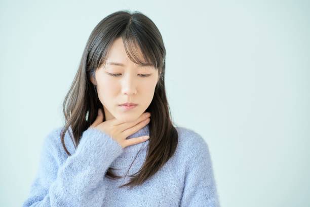 a young woman feels discomfort in her throat - 吐き気 日本人 ストックフォトと画像