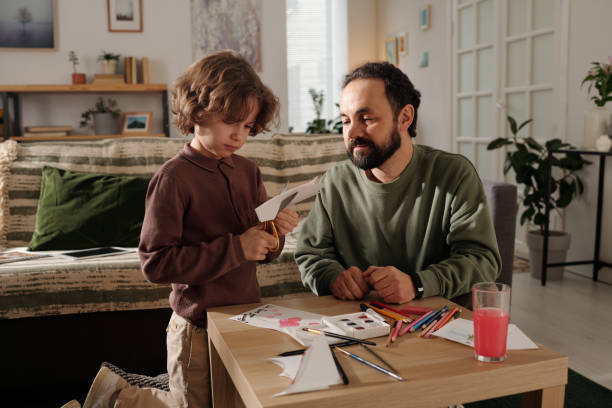istock Cute boy with scissors cutting paper 2058743810