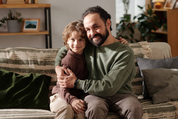 istock Happy father and son sitting on couch 2058743834
