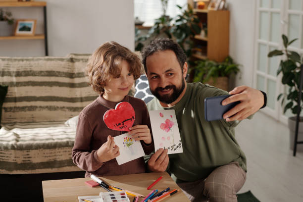 Man and boy with postcards taking selfie