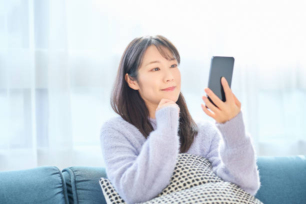 istock Young woman looking at smartphone screen 2058747598