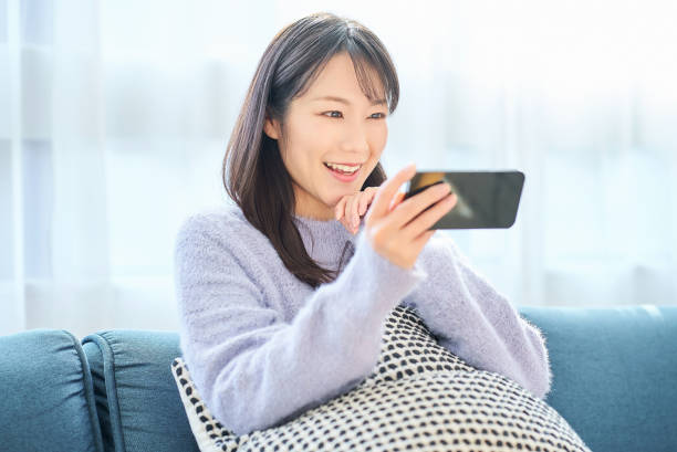 istock Young woman looking at smartphone screen 2058748152