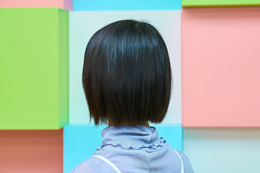 Back view of a beautiful black-haired woman and colorful background