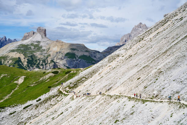 Sesto, Italia - July 09, 2022: people hiking on a trail circling the Tre Cime di Lavaredo, also known as \