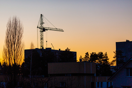 Tower crane silhouette in construction site.