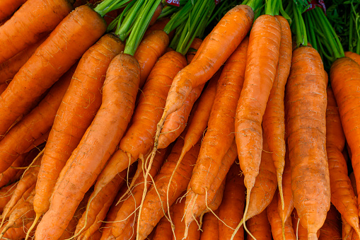 Close-up of organic carrots for sale at outdoor farmer's market.\n\nTaken in Santa Cruz, California, USA.