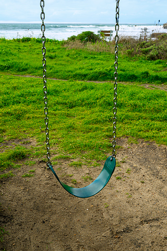 Close-up of playground swing on an empty oceanside playground.

Taken in Davenport, California, USA