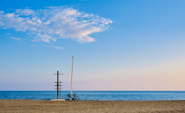 his stunning photograph captures the serenity of the coastline in Pedregalejo, Malaga. In the foreground, a bicycle rests beside a watchtower, while a cloud adorns the Mediterranean blue sky.