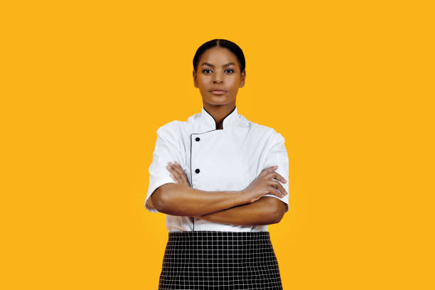 istock Professional black female chef in white uniform standing with her arms crossed 2058874300