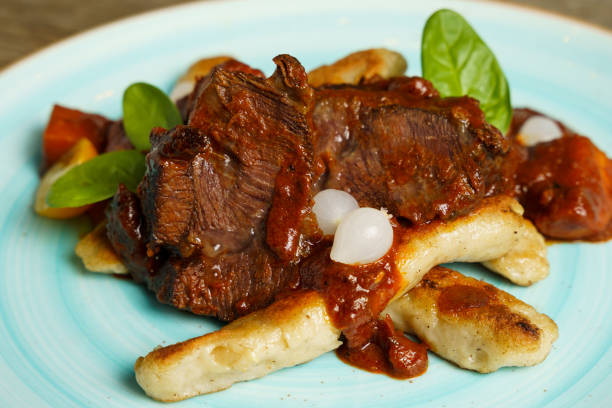 istock Cooked beef with vegetables on a wooden table 2058875386