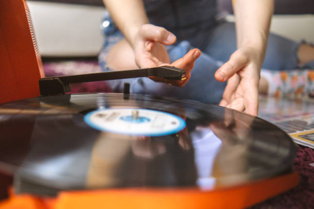 istock Young woman putting a record on her gramophone 2058876445