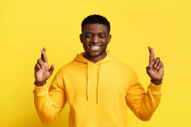 istock Excited black guy with closed eyes and crossed fingers 2058883836