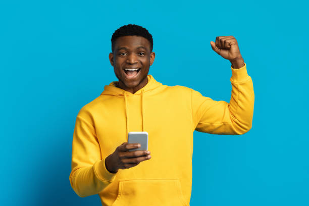 istock Emotional funny black guy using smartphone gesturing with excitement 2058883841