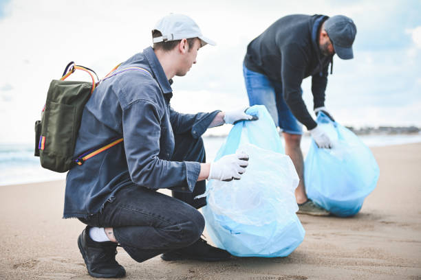 istock men collecting trash on the beach 2058885952