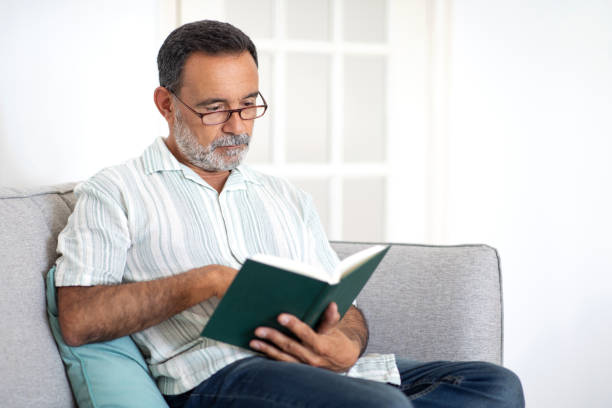istock Mature Man Resting With Book Enjoying Peaceful Reading At Home 2058900271