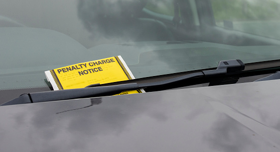 Penalty charge notice parking fine attached to car windscreen, transport, parking concept
