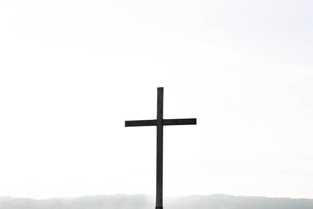 религиозная тематика, вид силуэта католического креста на белом фоне. копировать пространство - old cross shape stone weathered стоковые фото и изображения