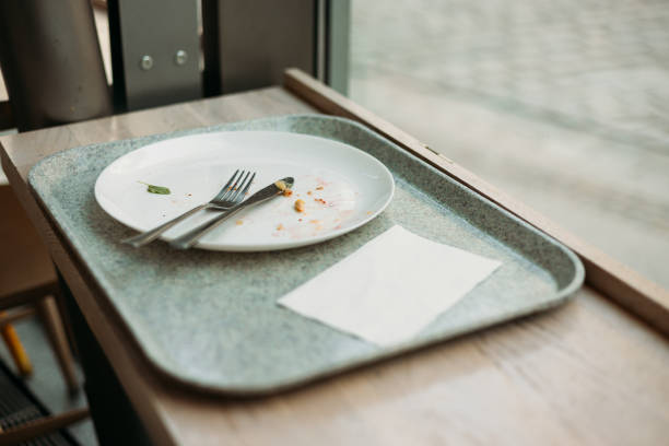lunch tray with Empty dirty dish. White plate with fork and knife on table