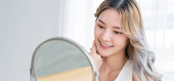 근접 촬영 초상화 젊은 아름 다운 아시아 소녀 거울 메이크업 루틴 복사 공간. -   brunette  뉴스 사진 이미지