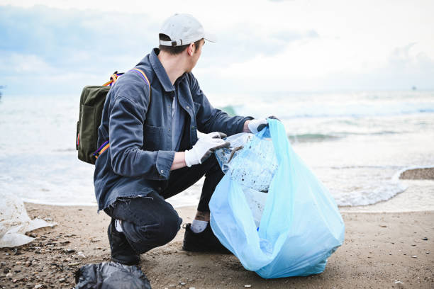 istock man collecting trash on the beach 2058991408