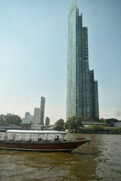 istock Bangkok river ferry with tall towers in the background. 2058994571