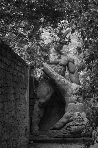 Bomarzo, Italy - 10 08 2023: Human figures sculptured in giant rocks wrestling in Bomarzo Sacro Bosco Park in Italy