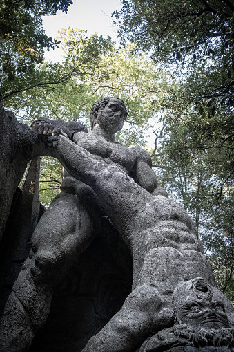 Bomarzo, Italy - 10 08 2023: Human figures sculptured in giant rocks wrestling in Bomarzo Sacro Bosco Park in Italy