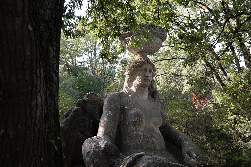 Bomarzo, Italy - 10 08 2023: Woman figure sculptured in giant rocks in Bomarzo Sacro Bosco Park in Italy