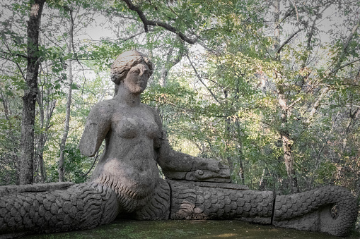 Bomarzo, Italy - 10 08 2023: Female figure sculptured in giant rocks in Bomarzo Sacro Bosco Park in Italy