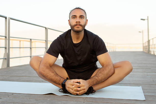 istock sporty man in activewear showcases flexibility with butterfly stretch outside 2059037400