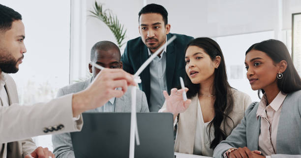 istock Wind turbine, computer and man in office team working on clean energy and sustainability planning. Engineering, construction project and architect job with eco friendly and biodiversity design 2059045373