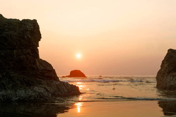 A late afternoon view of the Sun and sea stacks along the Pacific Ocean coastline in Olympic National Park.