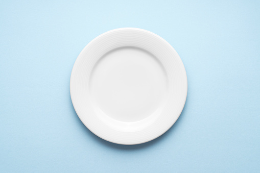 Blank dinner plate on blue background