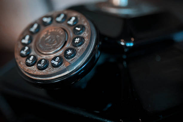 Closeup of an old vintage black telephone on a black background. Shallow depth of field.