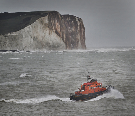 RNLI Lifeboat heads out to sea during a storm on a call in the eEnglish Channel, off the coast of Newhaven in East Sussex, UK