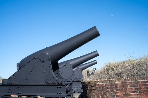 Baltimore, USA - February 18, 2024. A man with his son walking behind cannon row at Fort McHenry National Monument and Historic Shrine, Baltimore, Maryland, USA