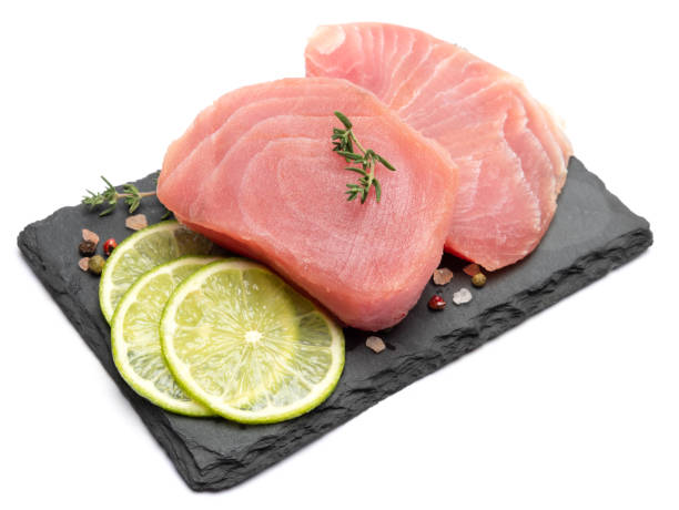 istock Fresh tuna Fish steak on stone serving board isolated on white background 2059321380