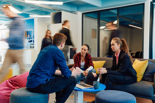 istock Multiethnic startup business team on meeting in a modern bright open space coworking office. Brainstorming, working on laptop. Group of coworkers walking around in motion blur 2059349710