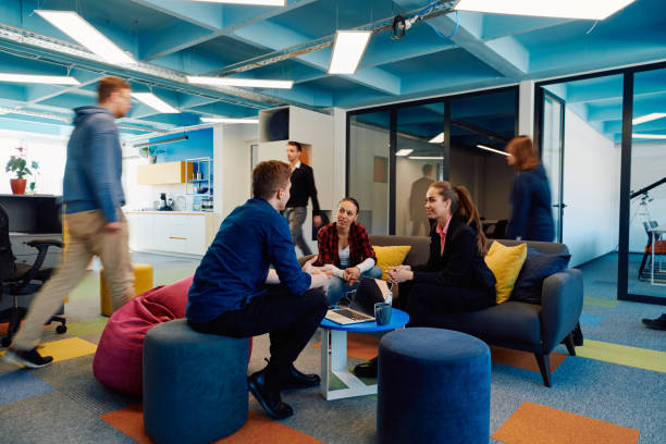 istock Multiethnic startup business team on meeting in a modern bright open space coworking office. Brainstorming, working on laptop. Group of coworkers walking around in motion blur 2059514231