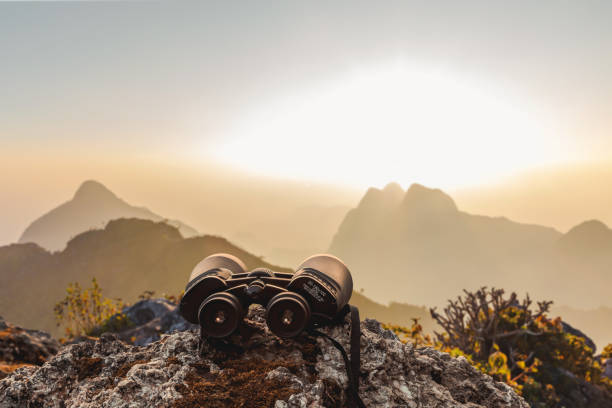 istock binoculars on top of rock mountain at sunset 2059547022