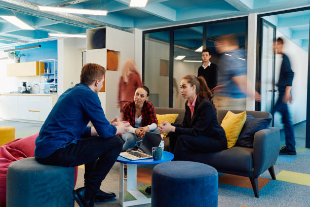 istock Multiethnic startup business team on meeting in a modern bright open space coworking office. Brainstorming, working on laptop. Group of coworkers walking around in motion blur 2059552703