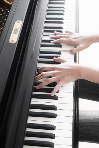 Piano player. Pianist hands playing grand piano keys. Music instrument keyboard closeup