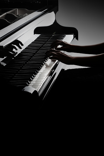 Piano player. Pianist hands playing piano keyboard. Music instrument closeup grand piano keys