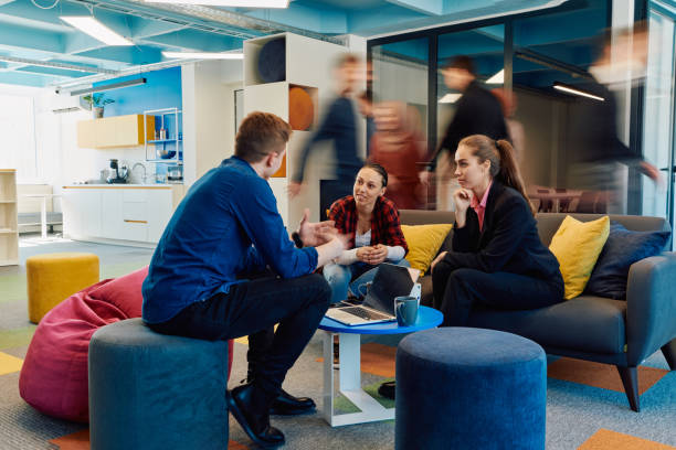 istock Multiethnic startup business team on meeting in a modern bright open space coworking office. Brainstorming, working on laptop. Group of coworkers walking around in motion blur 2059568007
