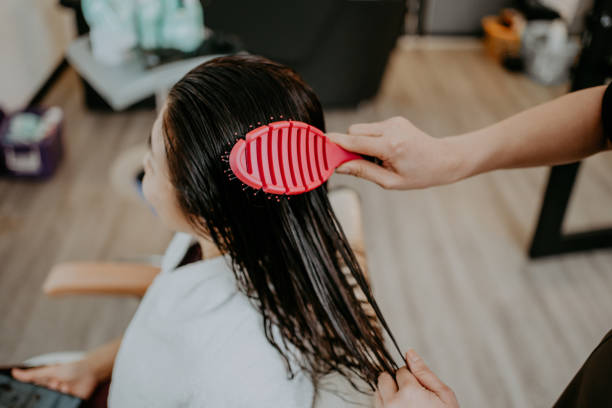 istock A hand combing wet hair with red comb 2059568095