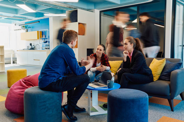 istock Multiethnic startup business team on meeting in a modern bright open space coworking office. Brainstorming, working on laptop. Group of coworkers walking around in motion blur 2059568151